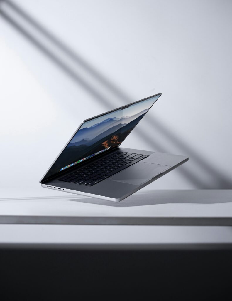Modern laptop levitating in a minimalist studio setting. Perfect for technology themes.